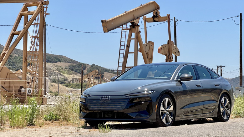 Un quattro e-tron gris A6 Sportback garé devant les derricks d'huile