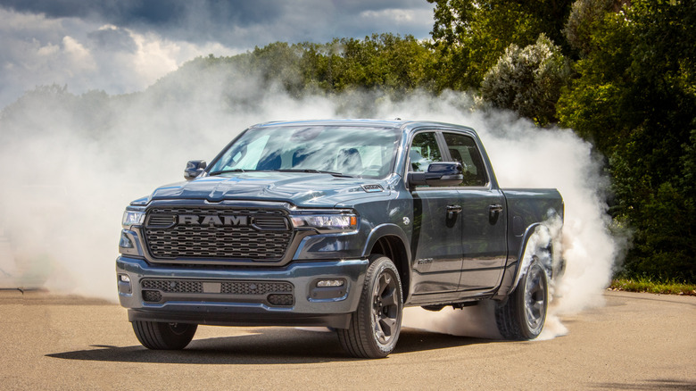 Un Ram 1500 Big Horn faisant un brûlage un jour nuageux avec des arbres en arrière-plan