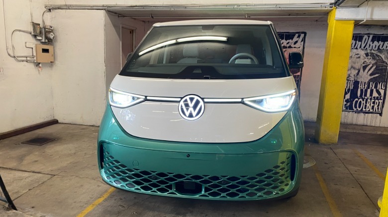Vue frontale du buzz d'identification verte et blanc dans un parking avec ses lumières allumées