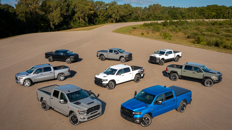 Un tas de RAM 1500 et 2500 camions garés sur un grand tronçon de parking entouré d'arbres par une journée ensoleillée